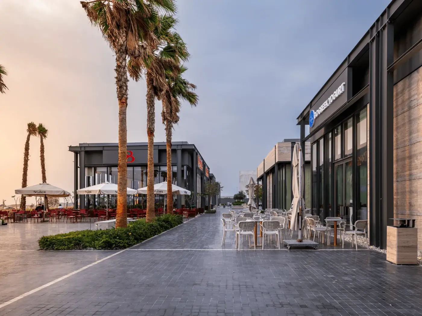 Jewar Harbour in Khobar: a palm-lined promenade between storefronts.