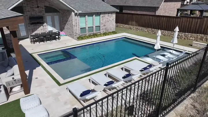A geometric pool with sun shelf, spa and loungers.